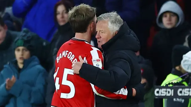 Patrick Bamford (left) hugs Chris Wilder in the dugout as he walks off the pitch