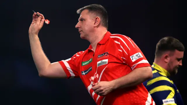 Krzysztof Ratajski throws a dart