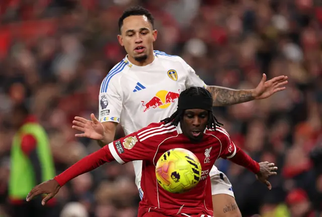 Jeremie Frimpong of Liverpool protects the ball from Noah Okafor of Leeds United during the Premier League match between Liverpool and Leeds United at Anfield on January 01, 2026 in Liverpool, England.