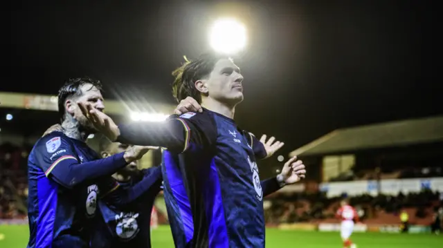 Adam Reach of Lincoln City holds his arms out wide in celebration after scoring his side's second goal during the 2-0 win at Barnsley