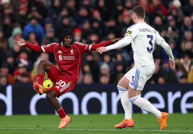 Jeremie Frimpong of Liverpool controls the ball whilst under pressure from Gabriel Gudmundsson of Leeds United (obscured) during the Premier League match between Liverpool and Leeds United at Anfield on January 01, 2026 in Liverpool, England.