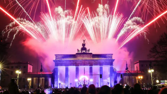 ireworks illuminate the sky over the Quadriga statue of the Brandenburg Gate during New Year's Eve celebrations in Berlin.