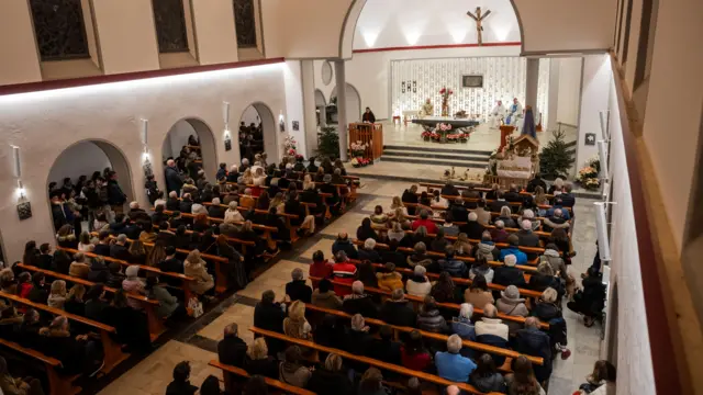 An aerial picture from inside the church, with worshippers sitting on pews