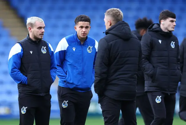 Bristol Rovers players standing on the pitch before kick-off talking