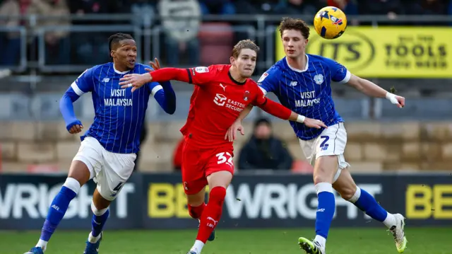 Dominic Ballard of Leyton Orient competes for the ball with Cardiff City players Gabriel Osho and William Fish