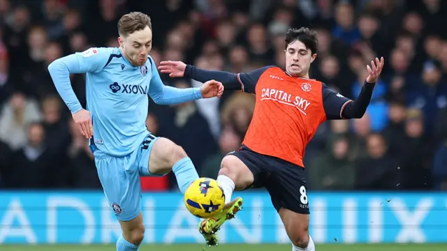 Dan Kemp of Stevenage competes for the ball with Liam Walsh of Luton Town
