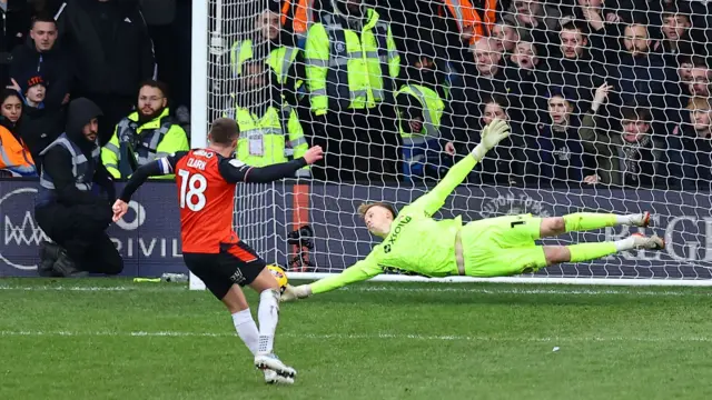 Luton's Jordan Clark sees his penalty saved by Stevenage's Filip Marshcall, diving low to his right