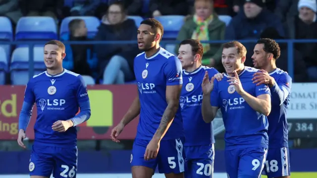 Bromley players celebrate Michael Cheek's opening goal at Tranmere