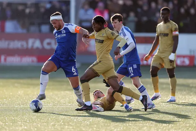 Paul Dawson of Macclesfield is put under pressure by Kaden Rodney and Yeremy Pino of Crystal Palace d