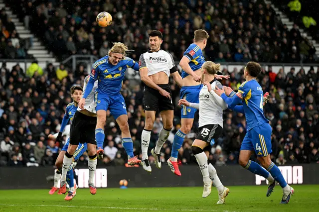 Danny Batth of Derby County heads the ball whilst under pressure from Sebastiaan Bornauw of Leeds