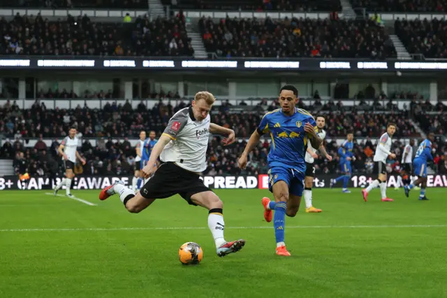 : Sondre Langaas of Derby County crosses the ball whilst under pressure from Noah Okafor of Leeds
