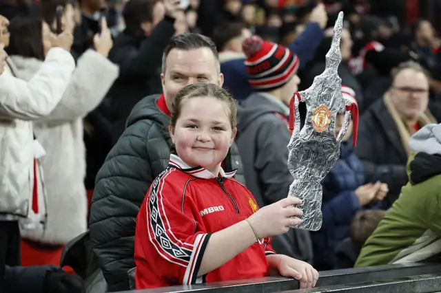 A young Man Utd fan holds a tin foil FA Cup
