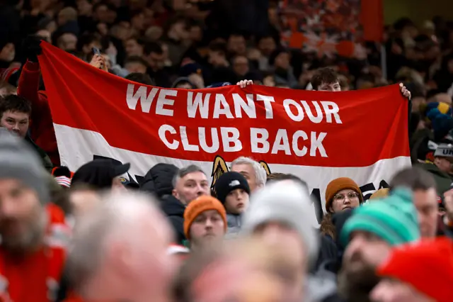 Fans hold a banner which reads 'we want our club back'