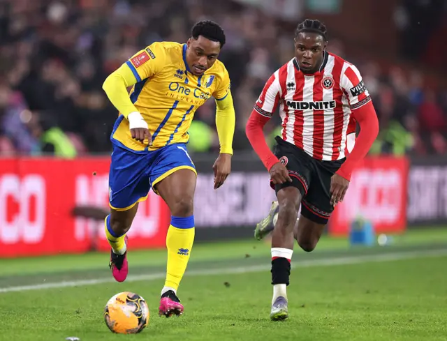 Victor Adeboyejo runs with the ball, pursued by Femi Seriki