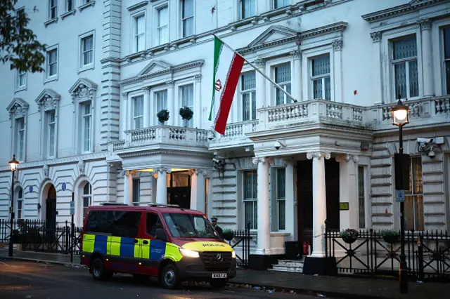 A metropolitan police van waits outside the Iranian Embassy, flying flag of the Islamic Republic of Iran in central London early in the morning