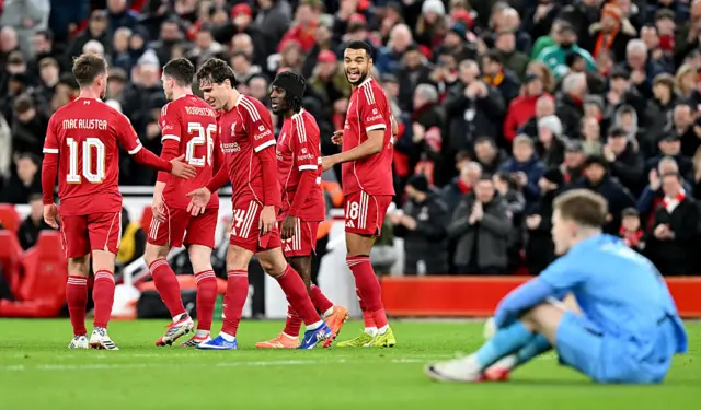 Liverpool players celebrate as Barnsley's keeper sits on the floor