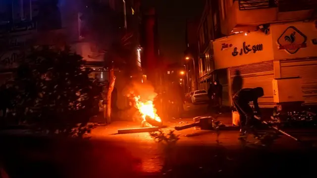 A protest in Tehran on 9 January. Image shows a a tyre on fire in a street at nightime