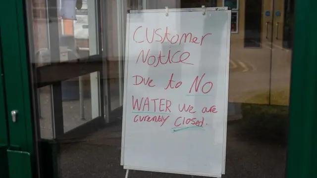 A sign reading 'Customer Notice. Due to no water we are currently closed'