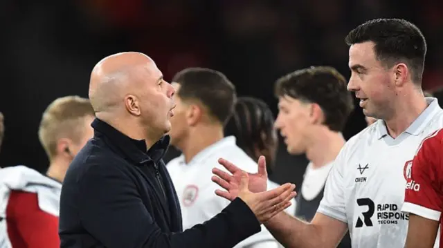 Slot shakes hands with a Barnsley player