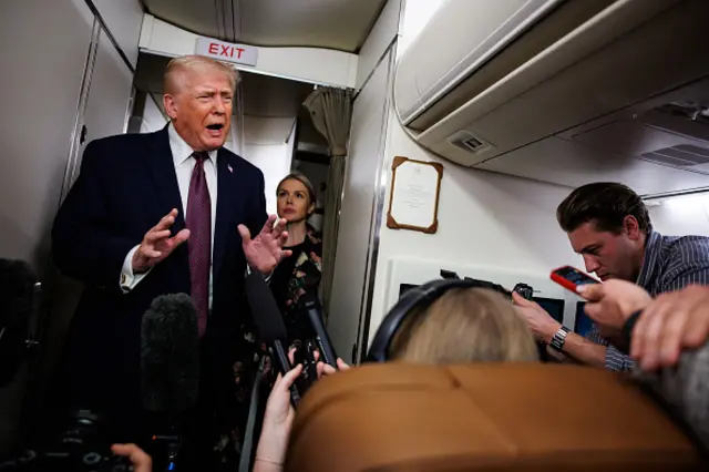 US President Donald Trump takes questions from the members of the press aboard Air Force One