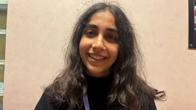 Fatemeh Sadat Mosavi has a black jumper and is smiling at the camera.