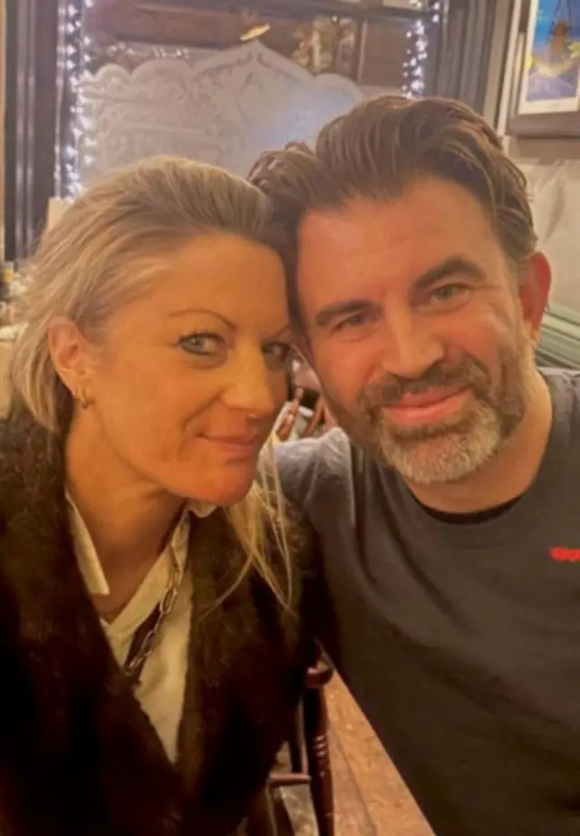 A picture of Hannah and Duncan smiling at the camera as they sit together