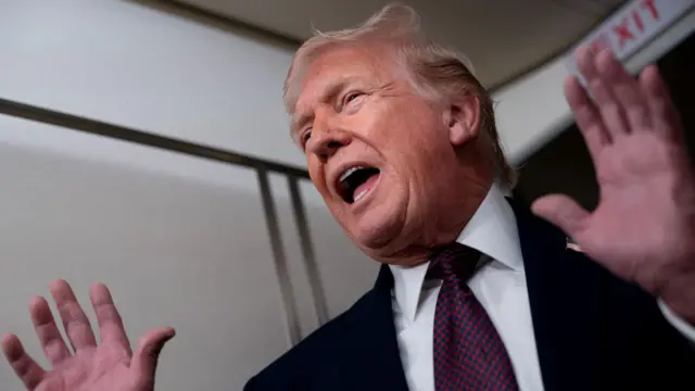 Donald Trump holds his hands up in a close-up photo