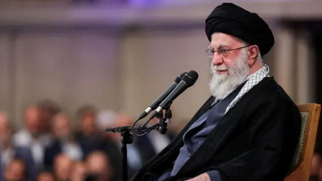 Iran's Supreme Leader Ayatollah Ali Khamenei sitting behind a microphone as he speaks during a meeting in Tehran