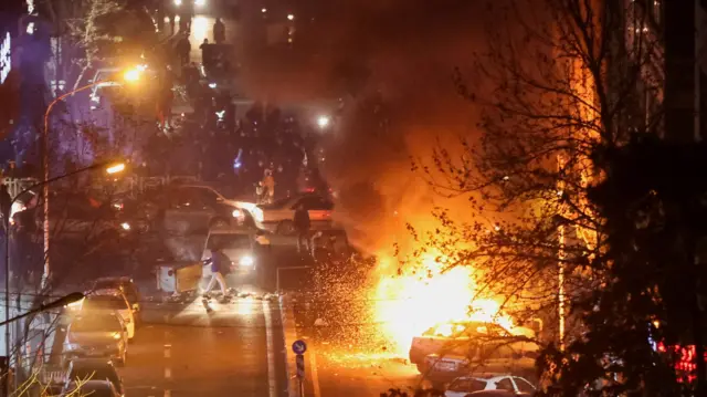 Cars burn in a street during a protest over the collapse of the currency's value, in Tehran, Iran, January 8, 2026