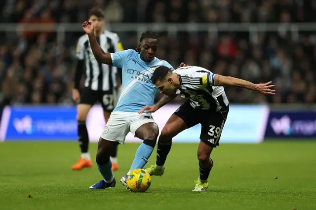 Jeremy Doku of Manchester City battles for possession with Bruno Guimaraes