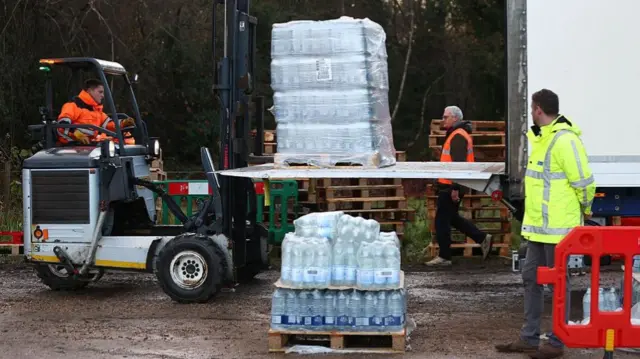 Volunteers from South-East Water assist members of the public load bottled water into their vehicles at a distribution point on December 2, 2025 in Tunbridge Wells, England.