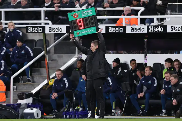 Fourth official Matthew Donohue lifts up a substitutes board indicated nine minutes