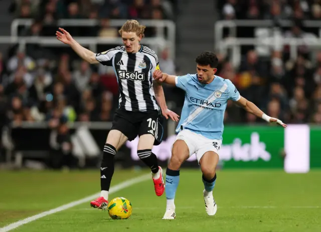 Newcastle United's Anthony Gordon in action with Manchester City's Matheus Nunes