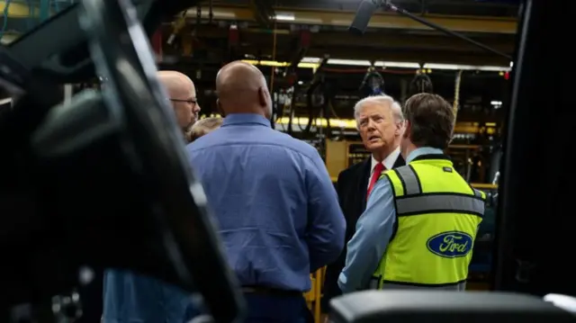 US President Donald Trump speaks with Jim Farley, CEO of Ford and Corey Williams, Ford River Rouge Plant Manager, as he visits a Ford production centre in Dearborn, Michigan.