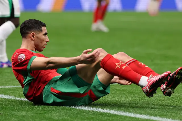 Hakimi sits on the floor after being shoved over
