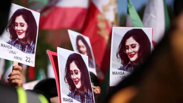 Placards with Mahsa Amini's photo are held at a protest in Washington DC