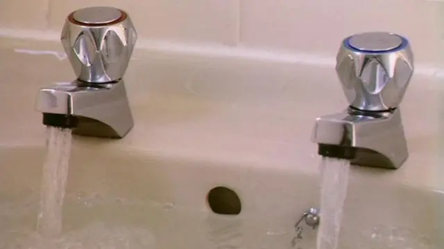 Two running taps into a basin full of water