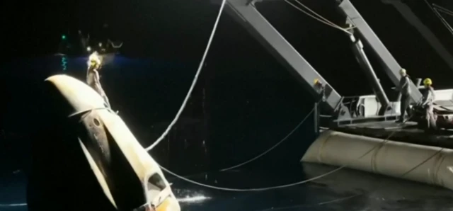 Rescuer climbs to the top of space capsule