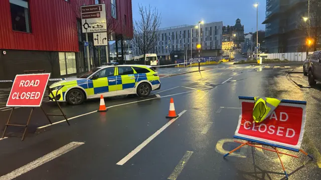 Road closed signs and a police car in a Plymouth street
