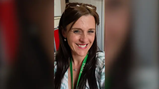 Woman with long dark hair smiling