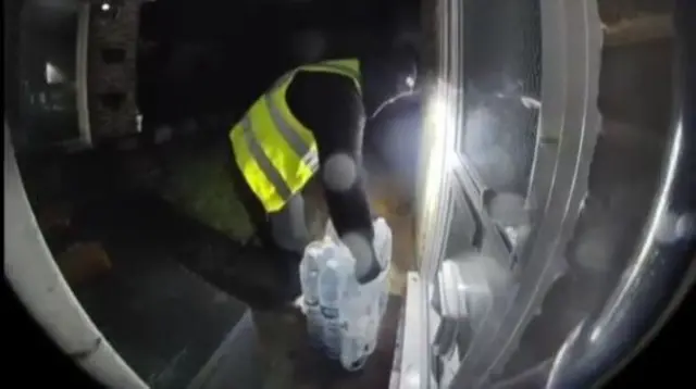 A person deliveries bottled water at night.
