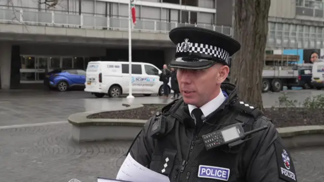 A police officer in uniform and wearing a hat.