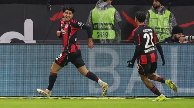 Eintracht Frankfurt's Mahmoud Dahoud celebrating his goal against Borussia Dortmund. He is wearing a black and red kit.