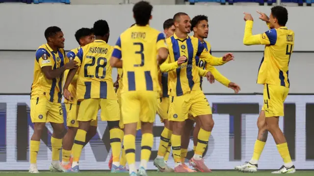 Maccabi footballers celebrate on a pitch