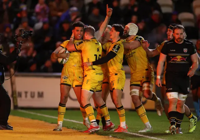 Rio Dyer celebrates scoring a try with Dragons team mates
