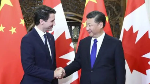 Justin Trudeau shaking hands with Xi Jinping