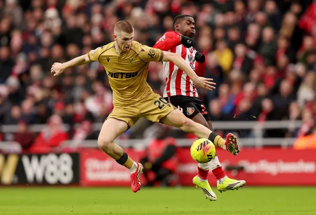 Adam Wharton of Crystal Palace is challenged by Noah Sadiki of Sunderland