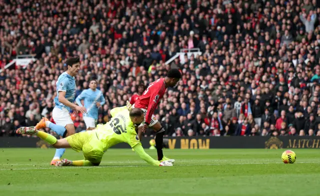 Manchester United's Amad Diallo in action with Manchester City's Gianluigi Donnarumma before scoring a goal that is later disallowed
