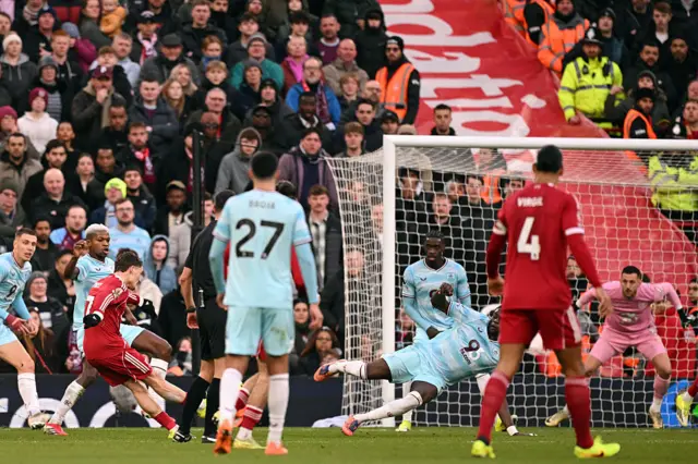 Liverpool's German midfielder #07 Florian Wirtz (2L) shoots to score the opening goa