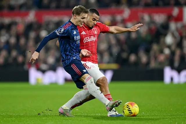 Martin Odegaard of Arsenal is tackled by Murillo of Nottingham Forest